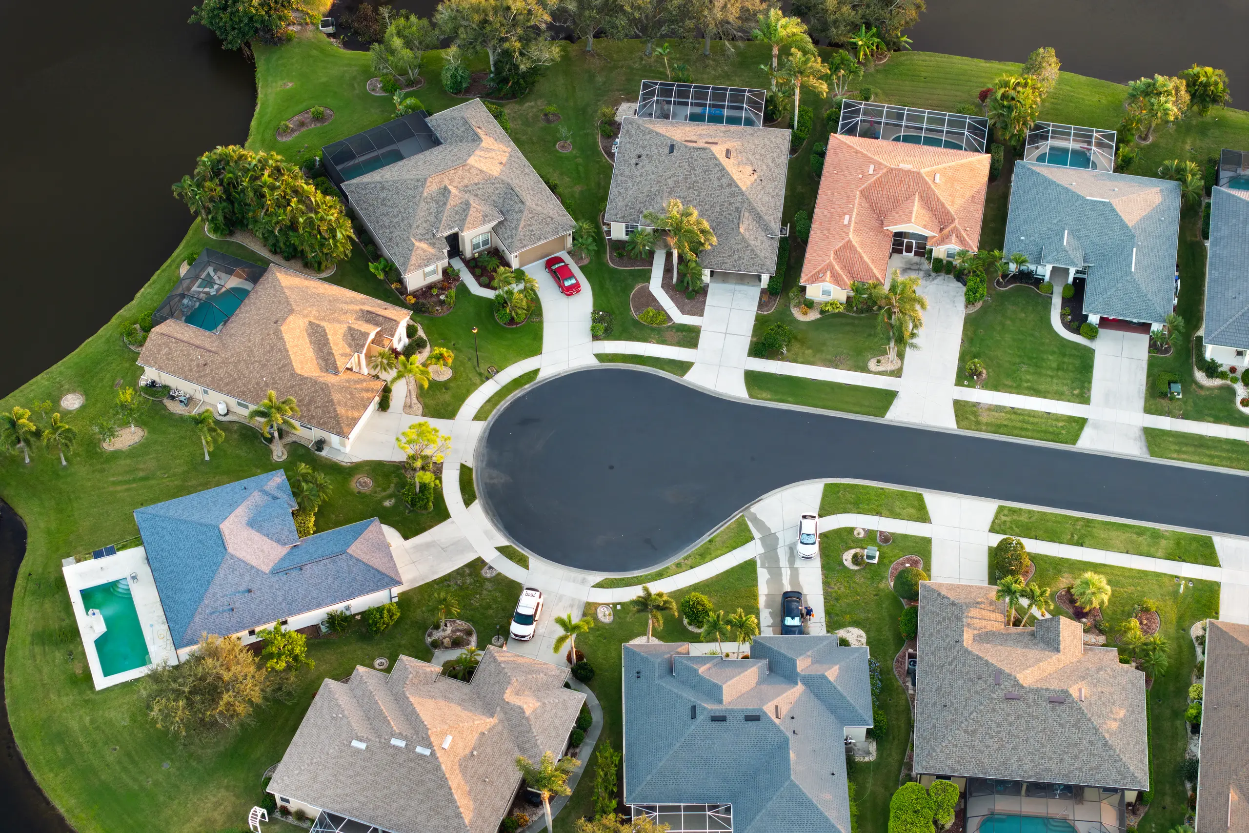 Aerial view of a palm-lined Florida cul-de-sac with pools and tiled roofs
