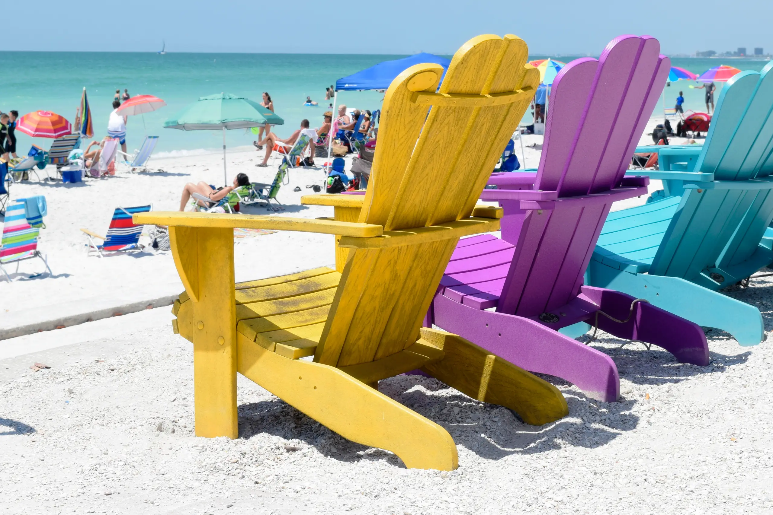 Brightly colored Adirondack chairs on a wide Atlantic beach